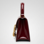 Maroon Gucci Dionysus top handle bag with a silver-tone tiger head closure.