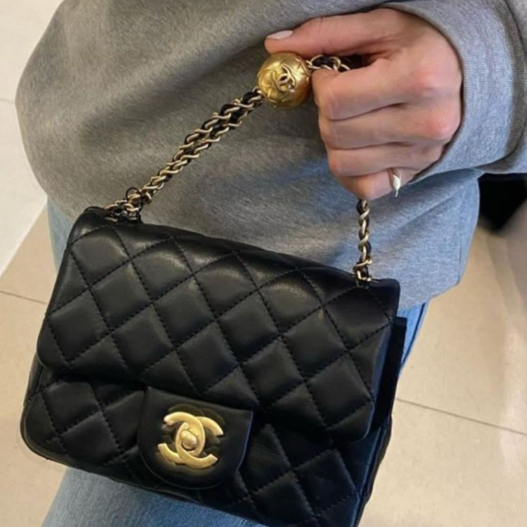 Chanel Mini Flap Bag in black lambskin leather with a gold-tone chain strap and CC turn-lock