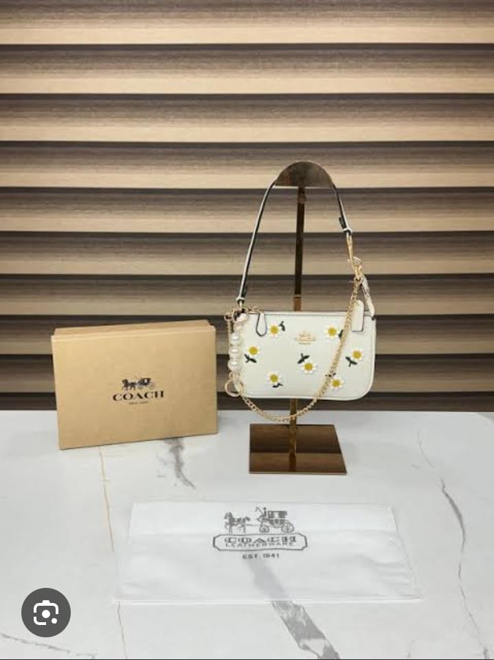 Coach Nolita 19 with Daisy Embroidery in refined pebble leather and white color.