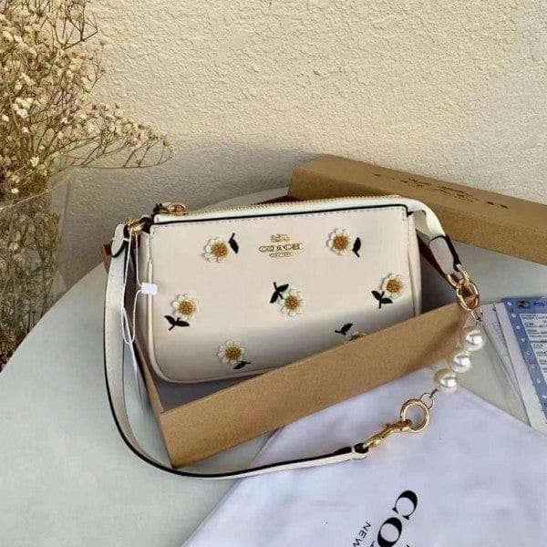 Coach Nolita 19 with Daisy Embroidery in refined pebble leather and white color.