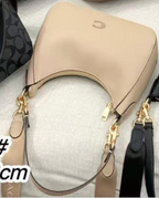 Coach Small Jonie 22 half-moon leather shoulder bag in a neutral color.