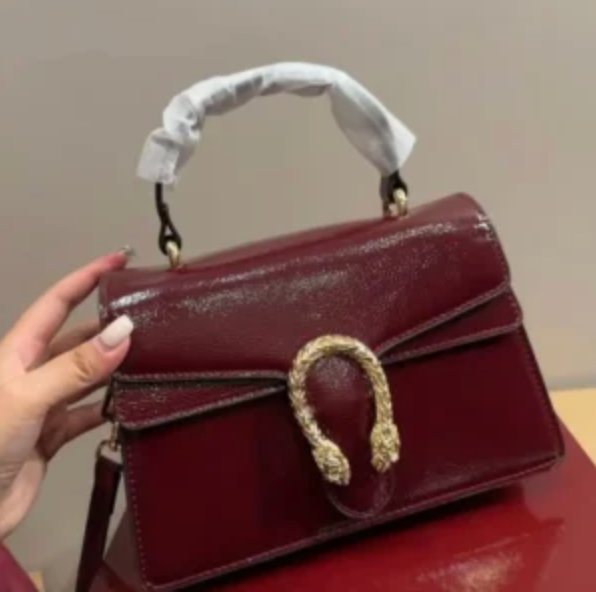 Maroon Gucci Dionysus top handle bag with a silver-tone tiger head closure.