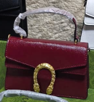 Maroon Gucci Dionysus top handle bag with a silver-tone tiger head closure.