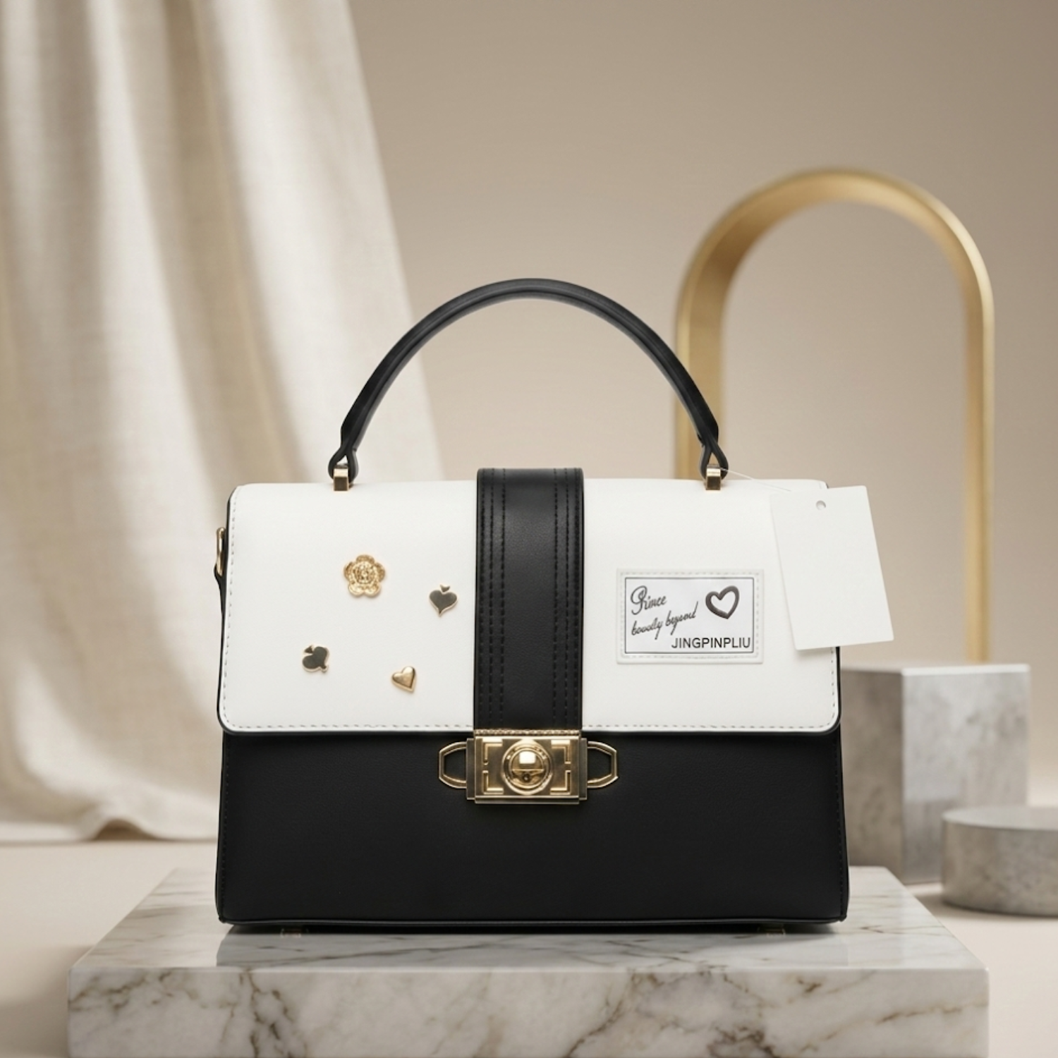 black and white top-handle satchel bag with a shoulder strap and gold-tone hardware