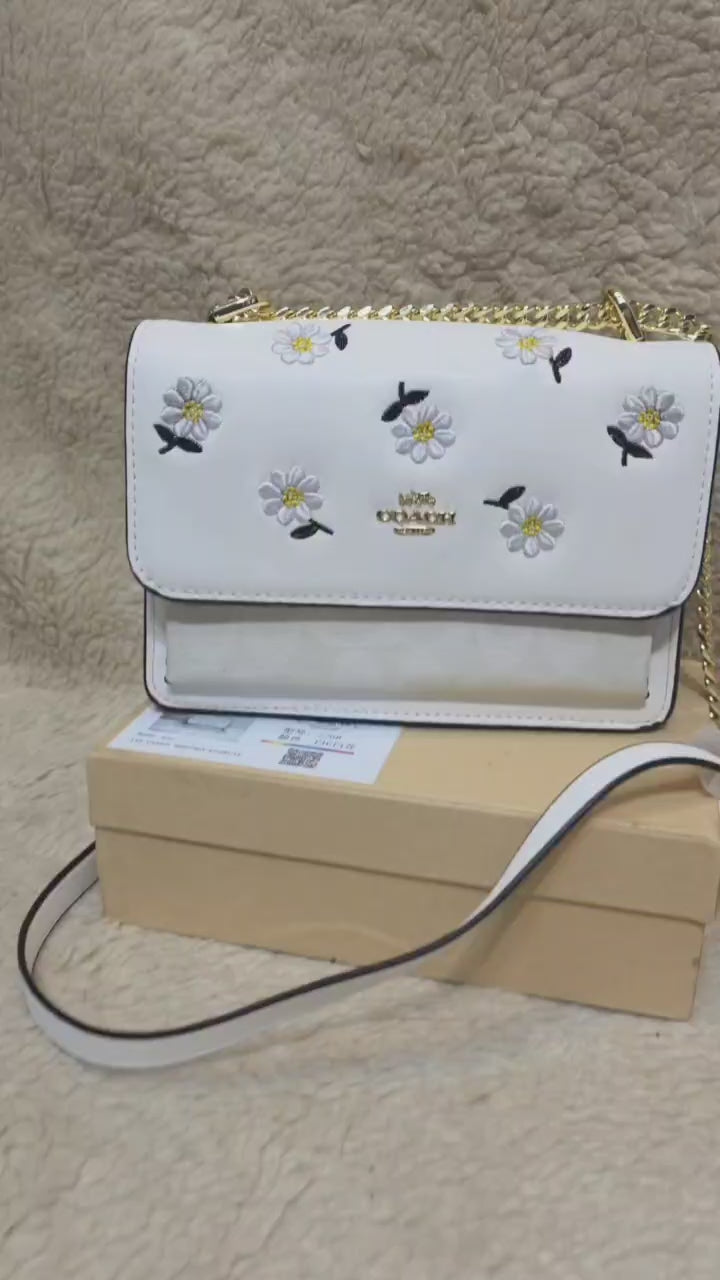 Coach Klare crossbody bag with daisy embroidery in white smooth leather with a gold-tone chain strap