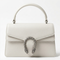 white Gucci Dionysus top handle bag with a silver-tone tiger head closure.